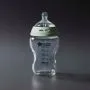 Glass baby bottle against a grey background