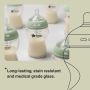 Glass baby bottles containing milk with text about resistant glass.