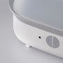 Close up of the buttons on the front of a steam steriliser against a grey background