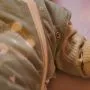 Close up of a woman’s hand zipping up a baby’s Swaddle Bag