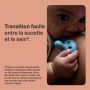 Bébé appuyé sur le sein de sa mère et tenant une sucette