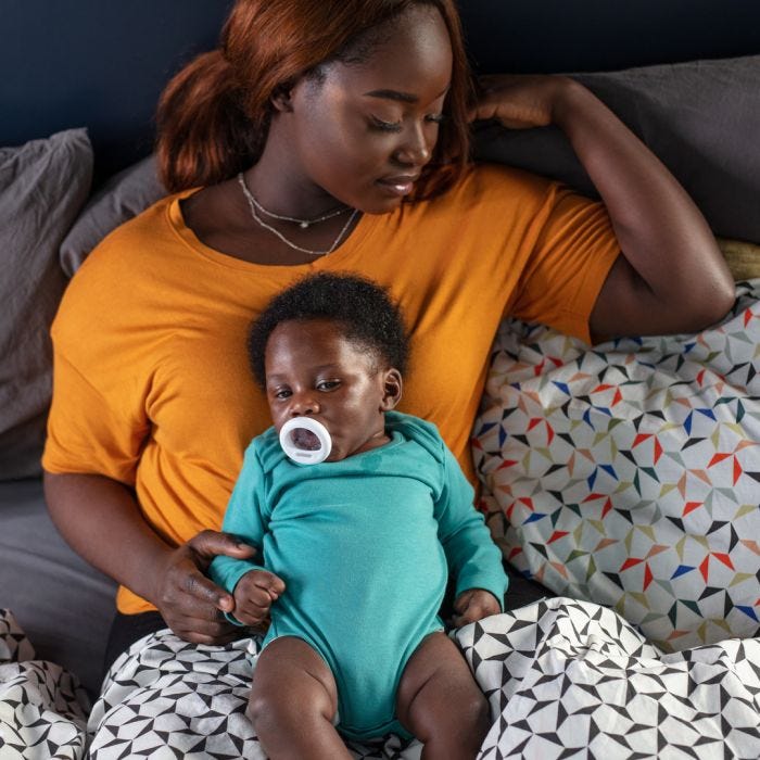 mum and baby holding breast like soother