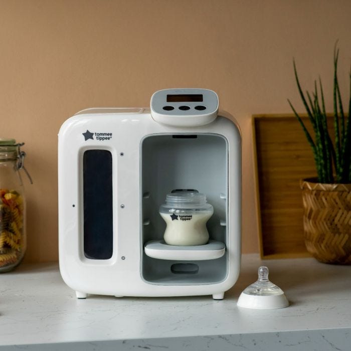 White Perfect Prep Day & Night machine on a kitchen counter with a baby bottle on the bottle stand