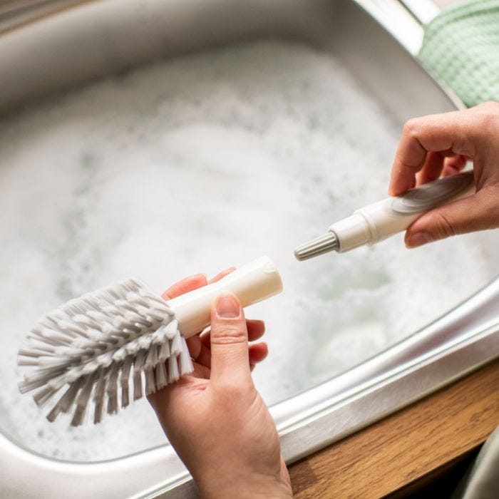 Une personne remplace le goupillon par la tête du goupillon 2in1Clean
