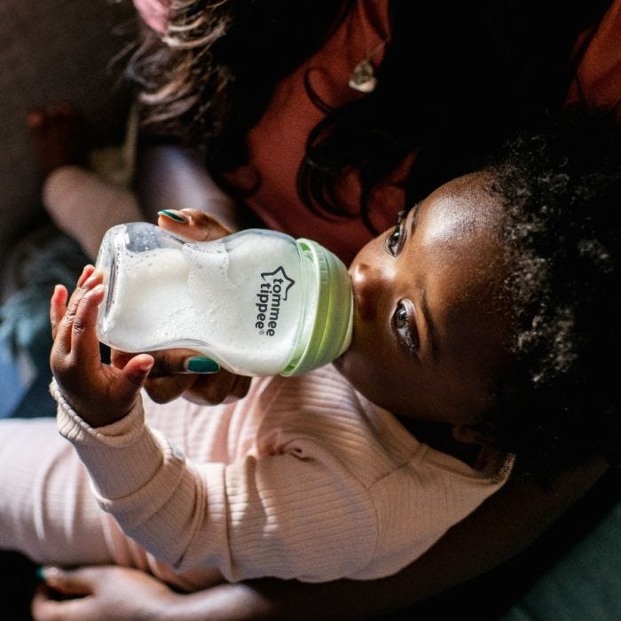 Baby feeding from a Closer to Nature glass baby bottle.