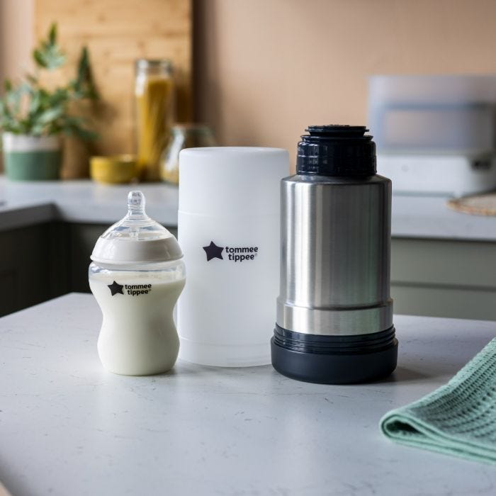 Thermal flask, frosted base and baby bottle placed on a kitchen counter