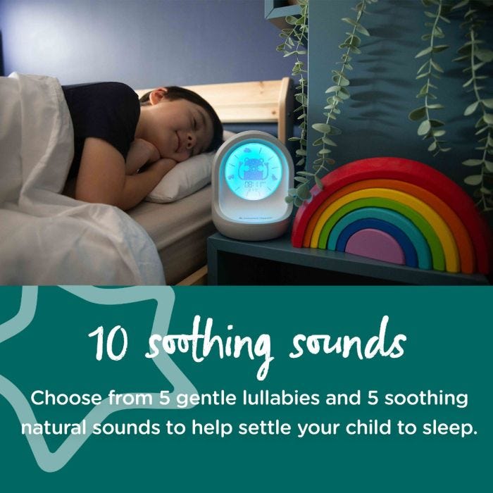 Toddler sleeping next to his trainer clock with text about it having 10 soothing sounds