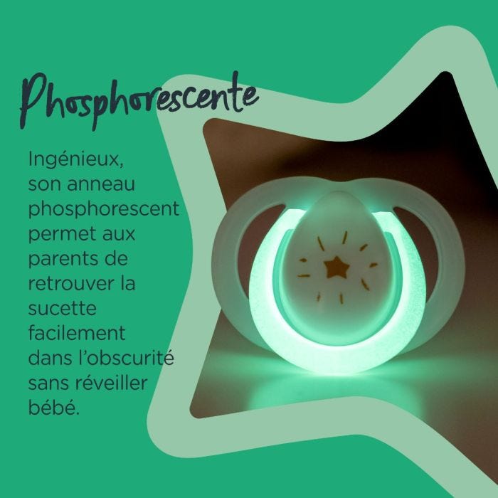 Sucette brillant en vert dans le noir entourée d&apos;une étoile verte indiquant qu&apos;elle est phosphorescente.