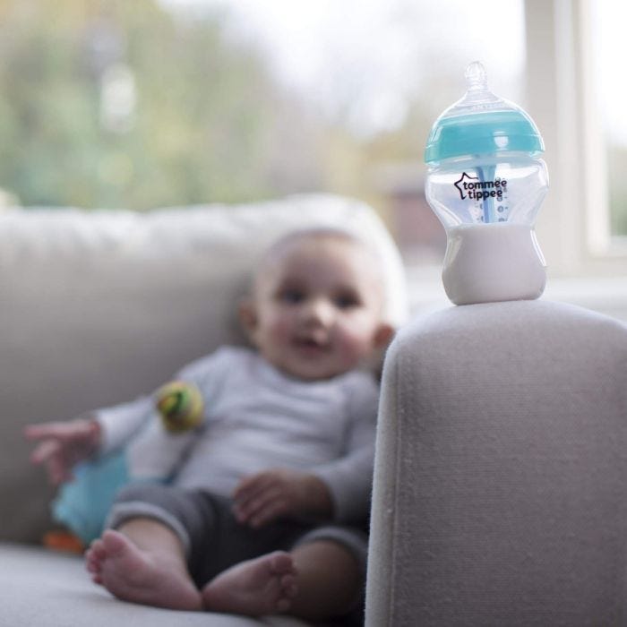 advanced anti colic baby bottle on sofa with baby in background