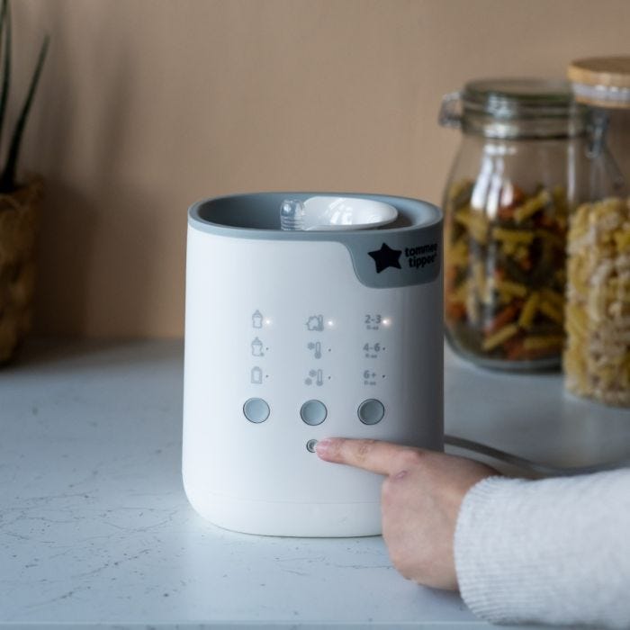 Someone pressing a button on their bottle warmer