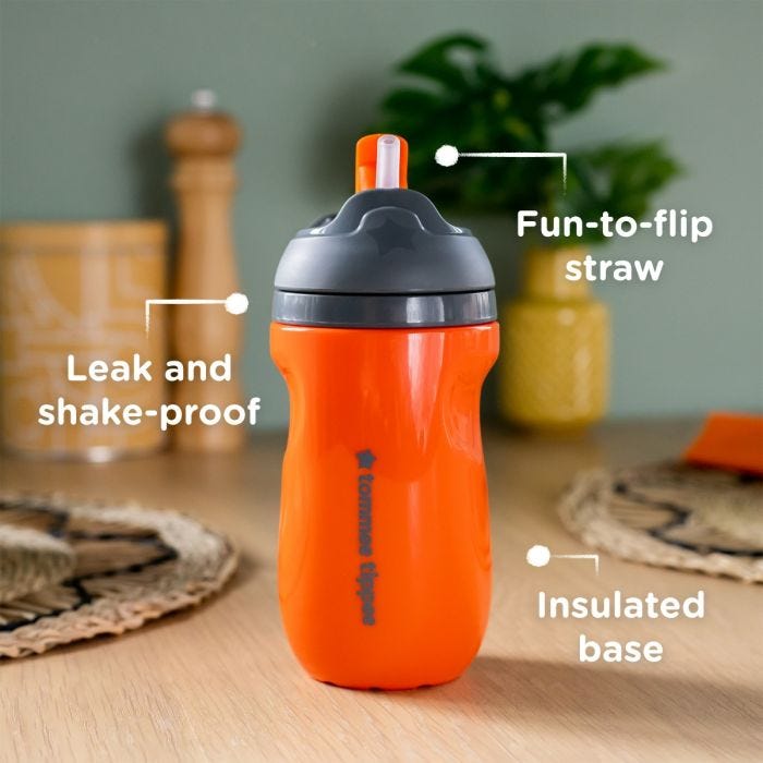 Orange straw cup on a kitchen counter with pointers to its leak proof lid, fun-to-flip straw and insulated base