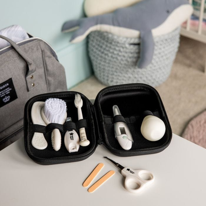 Baby healthcare kit accessories in open black travel case on a white table.