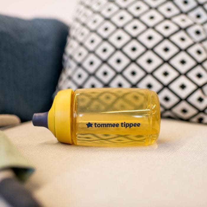 Sportee Water Bottle in Yellow place on it&apos;s side on a sofa