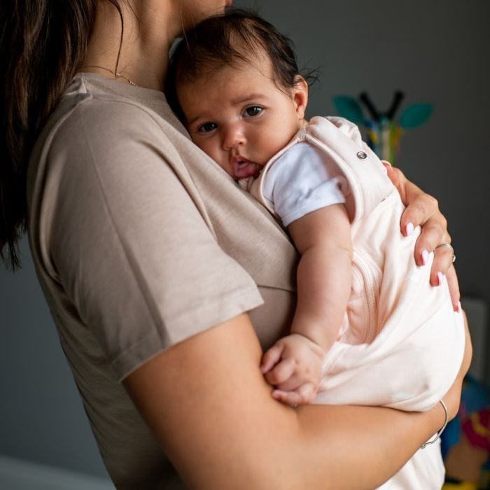 mum holding baby wearing The Original Grobag Swaddlebag 