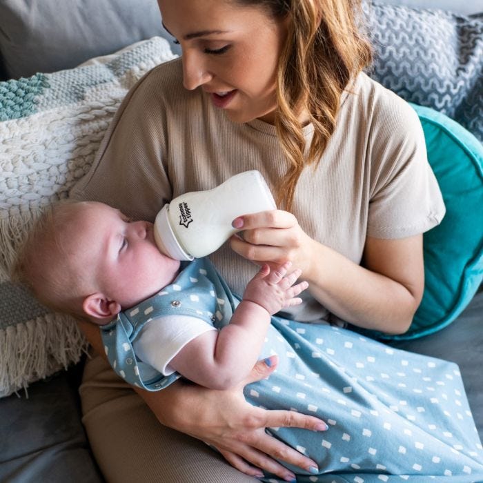 Mum feeding baby while wearing The Original Grobag Swaddlebag 
