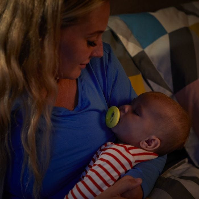 Mum holding baby who is holding Breast-like Night Time Soother