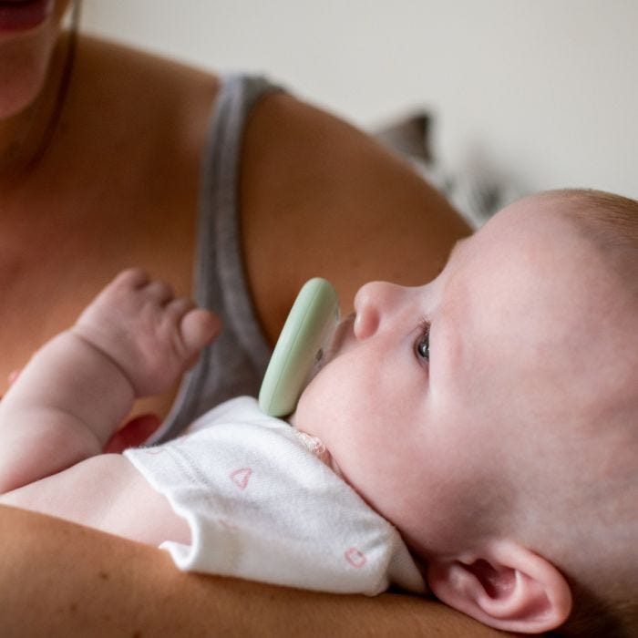 Bébé avec une sucette imitant la forme du sein à la bouche