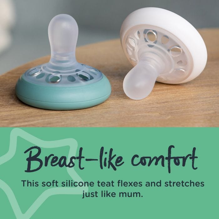 One green and one white breast-like soother next to each other on a brown table with text stating they offer breast-like comfort.