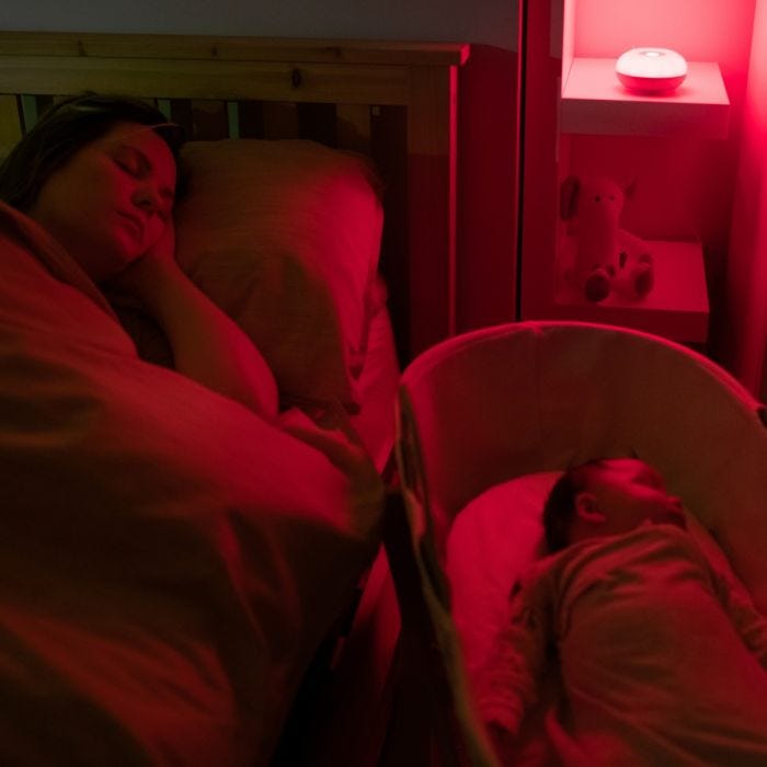 Mum and baby sleeping with red-glowing Dreammaker on the shelf