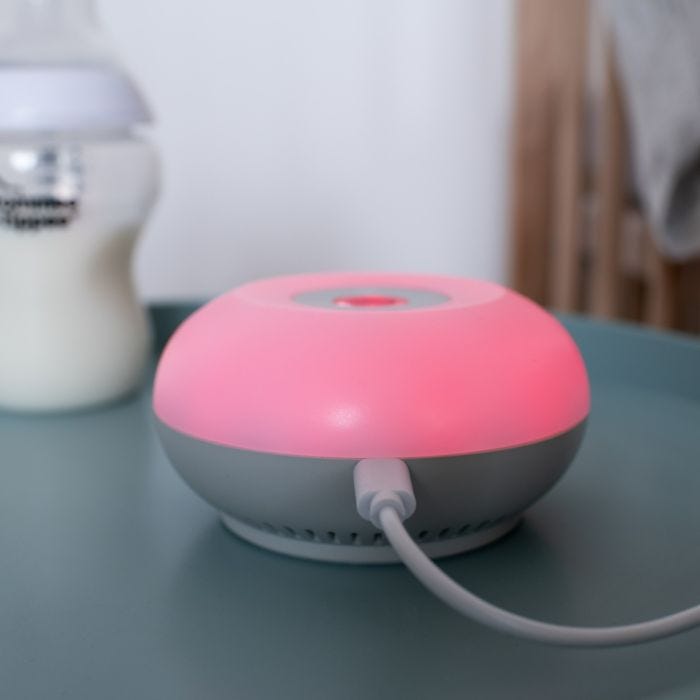  Dreammaker glowing red on a kitchen counter with its charger plugged in