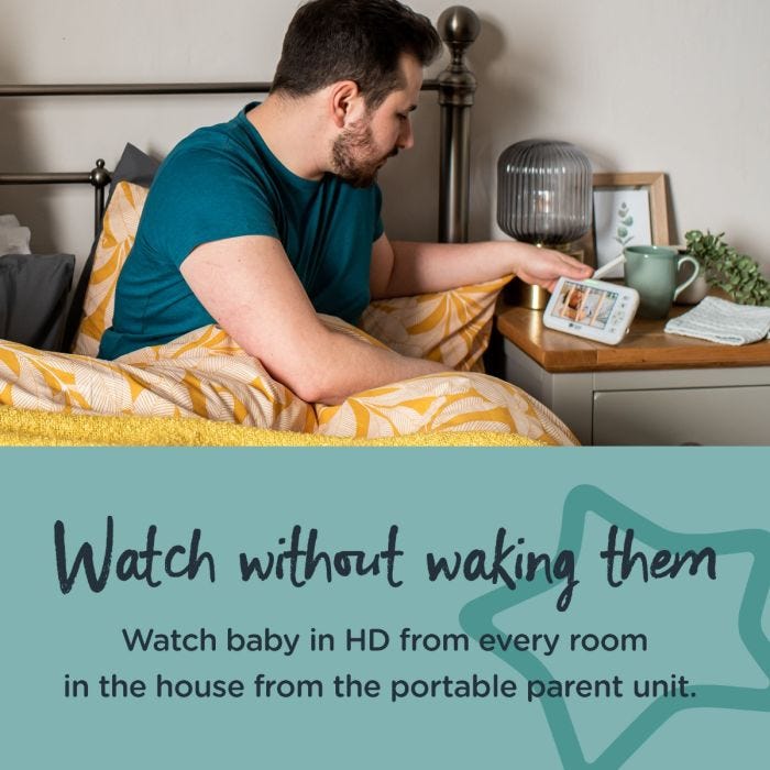 Image of Dad in bed leaning over to look at the parent unit watching baby with text saying that you can watch them without waking them.