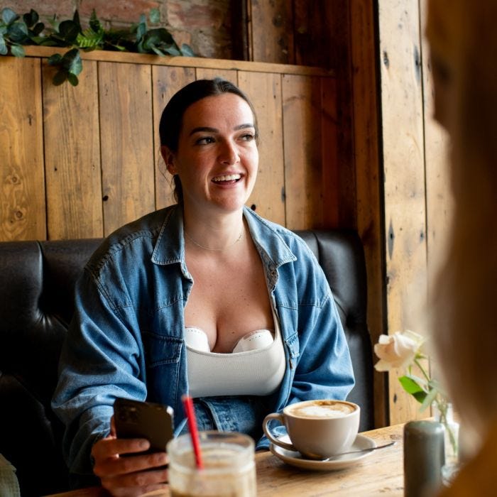 Woman using the double wearable breast pump at a café