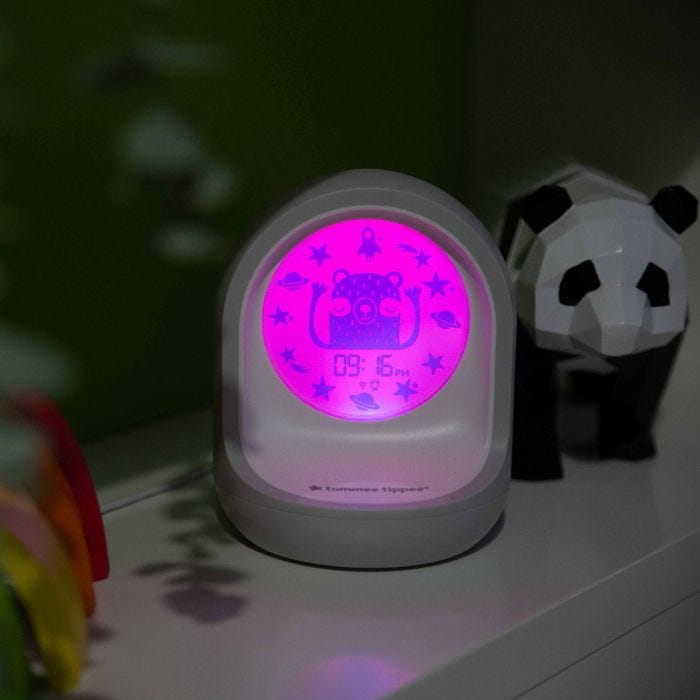 Connected sleeping trainer clock on a windowsill with a pink face