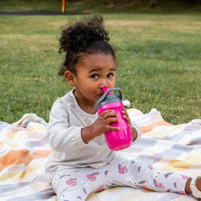 Close up of little girl holding the orange insulated straw cup