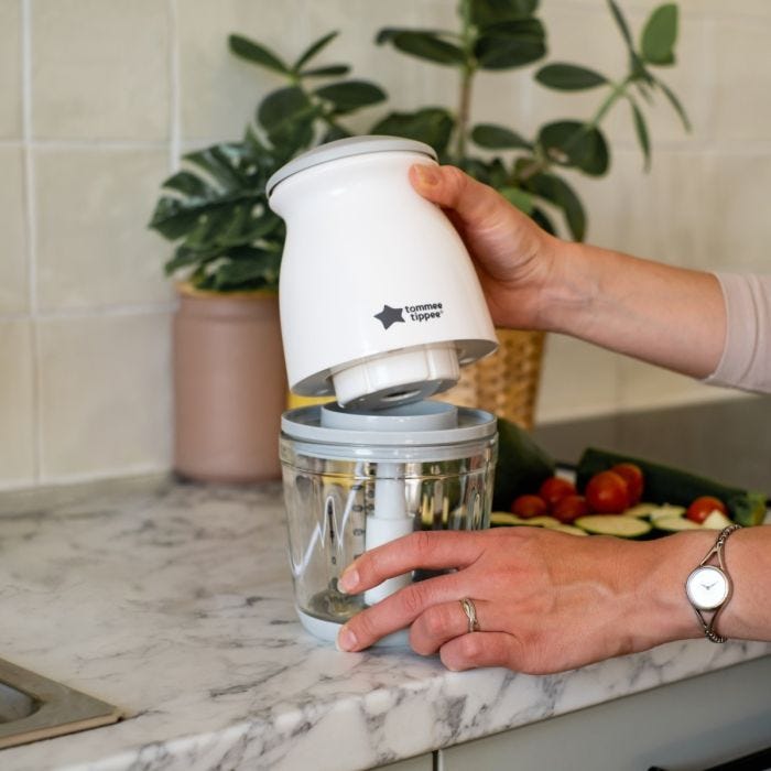 Person removing the top of the mini baby food blender from its glass bowl
