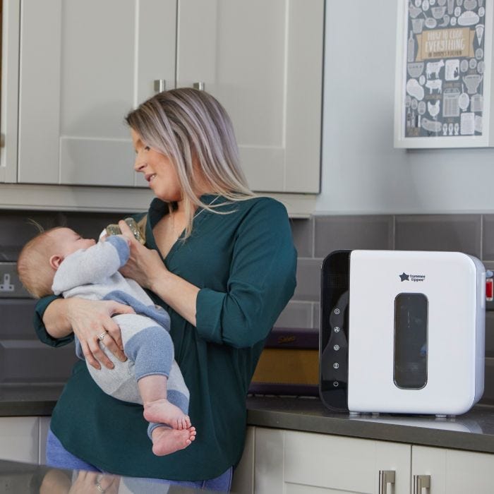 mum feeding baby with uv sterilizer in foreground