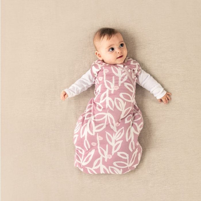 baby in Tommee Tippee botanical snuggle with both hands extended and eyes looking in one direction 