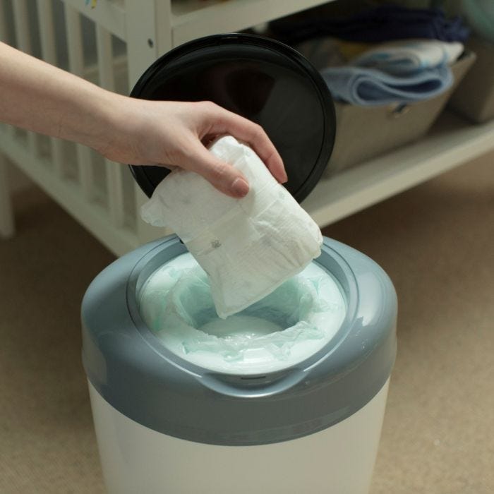 Someone placing a dirty diaper into their Simplee bin