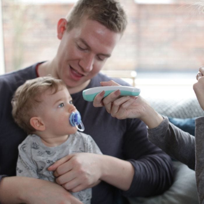 dad-holding-baby-whilst-using-no-touch-forehead-thermometer
