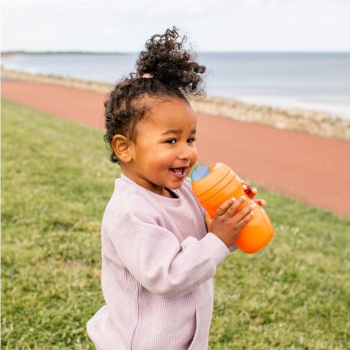 Little girl holding a Sippee Cup while outside