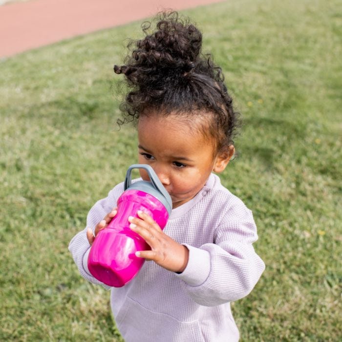 Litte girl drinking from pink sportee bottle while outside