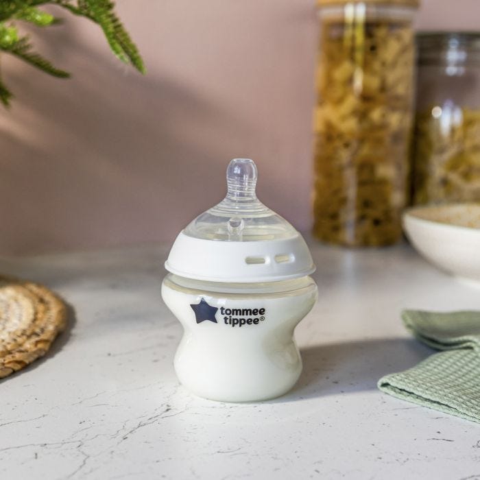 Natural Start baby bottle filled with milk on a kitchen counter