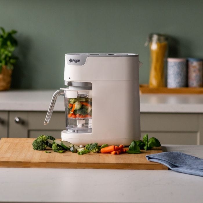 White quick cook on kitchen counter with vegetables inside the basket and on the chopping board