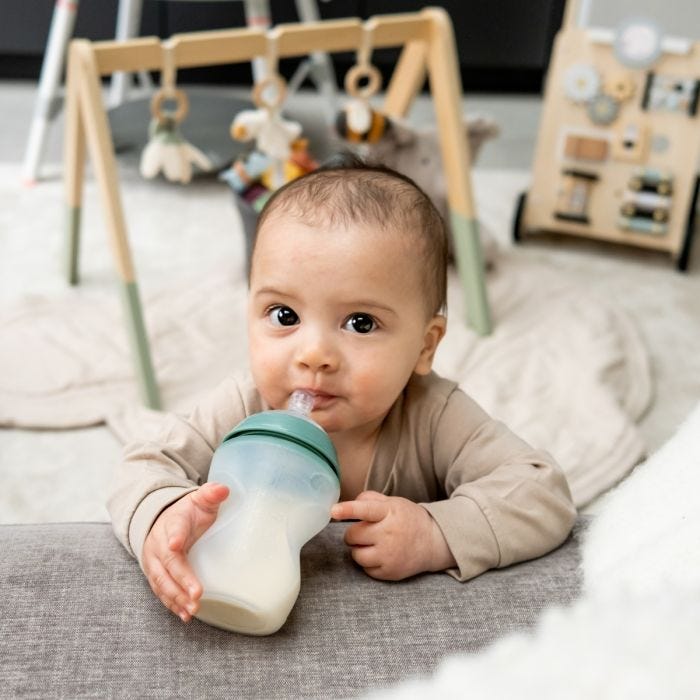 Baby holding a Closer to Nature silicone baby bottle