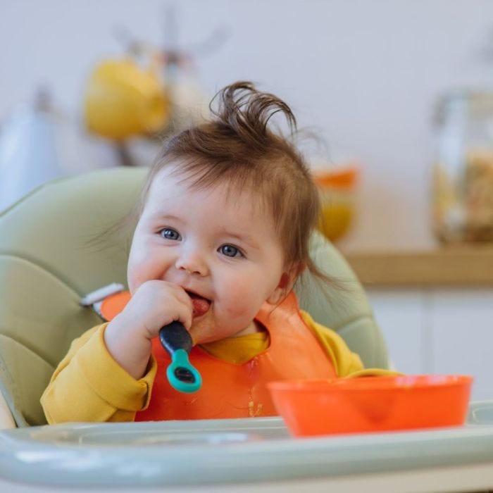Baby using a Smushee spoon to eat her breakfast