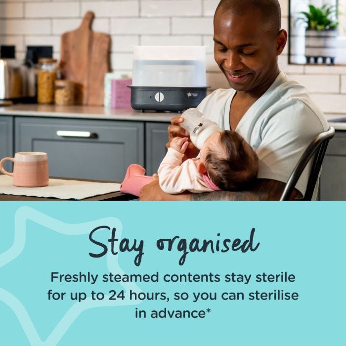 Dad feeding baby in kitchen with black steam steriliser in the background and text about staying organised