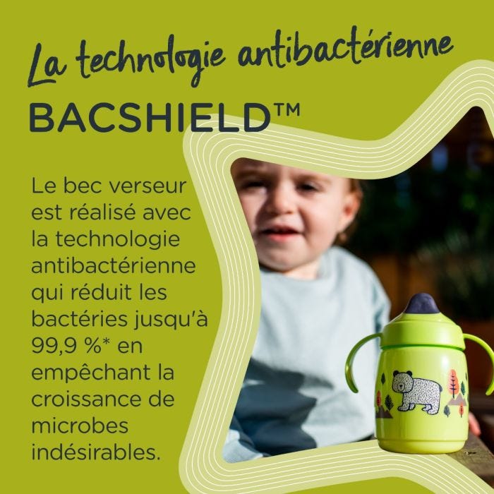 Tasse d&apos;apprentissage verte sur table en extérieur, avec texte sur le bec antibactérien BACSHIELD