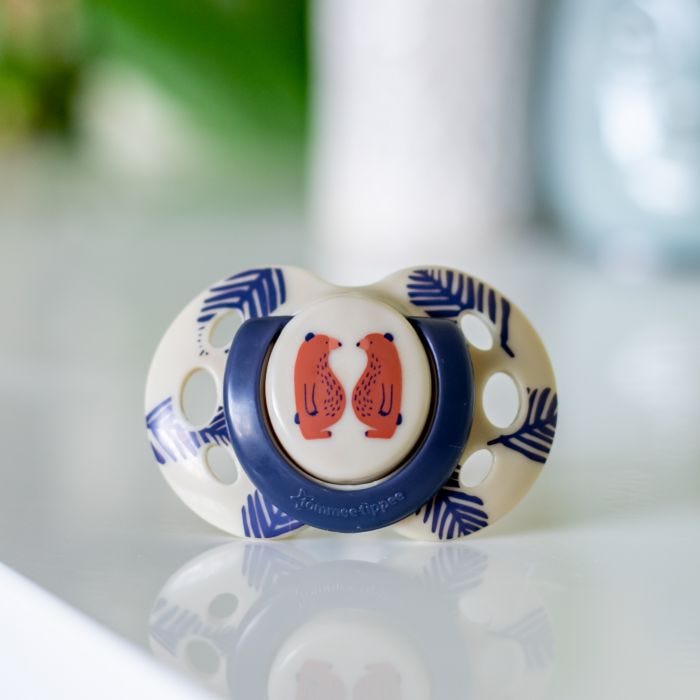 Beige Fun Style soother with a bear design, on a white table.