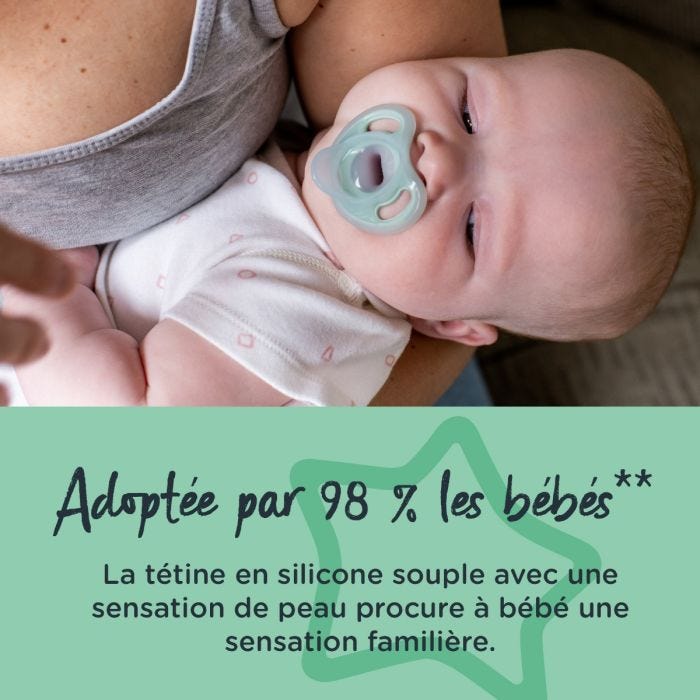Bébé tenu par sa mère avec une sucette dans la bouche.
