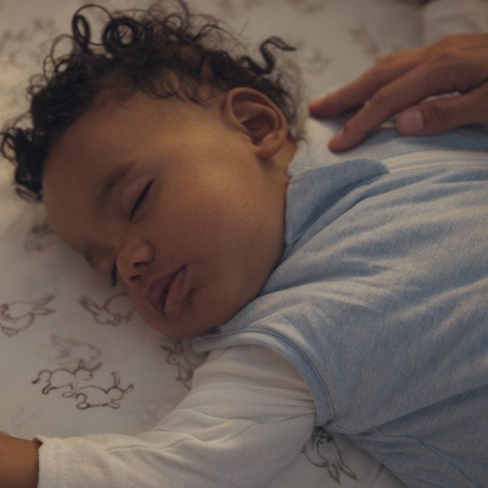 Child sleeping in The Original Grobag Blue Marl Sleepbag