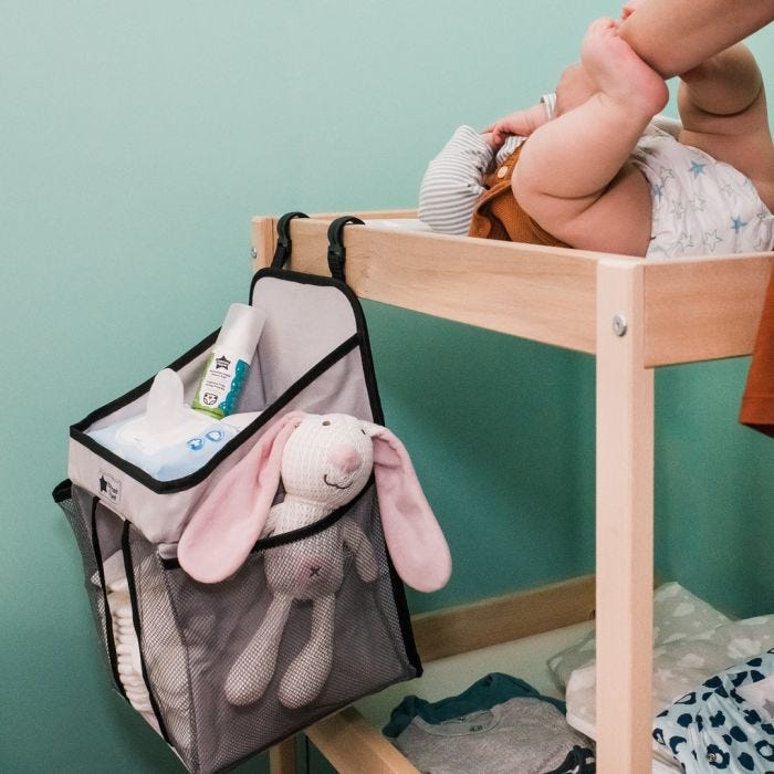 Nappy Change Caddy hanging on ide of change mat with mum changing baby