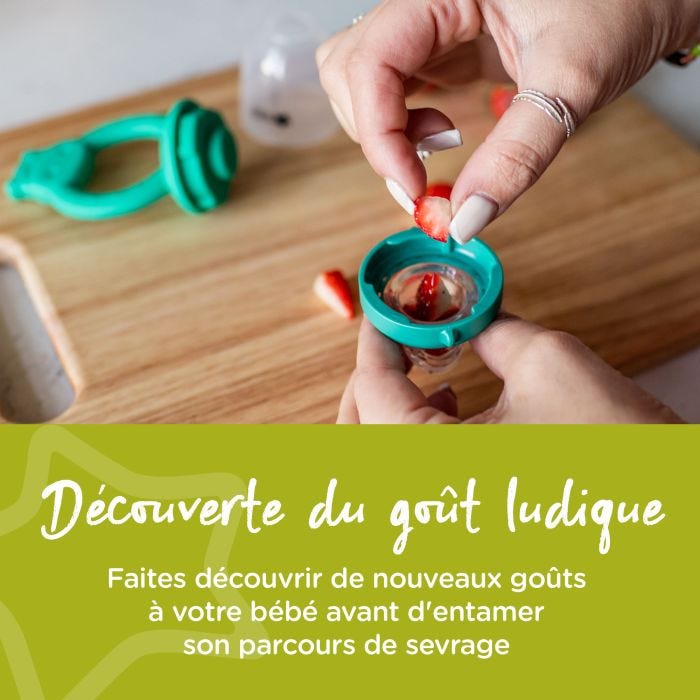 Maman mettant des fraises coupées dans la grignoteuse d&apos;alimentation
