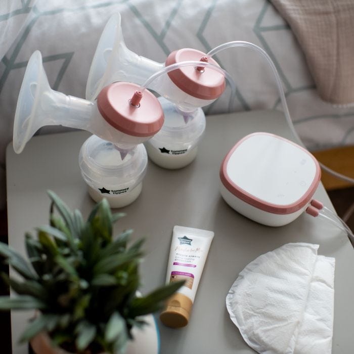 Aerial view of double electric breast pump with power unit placed on grey bedside table