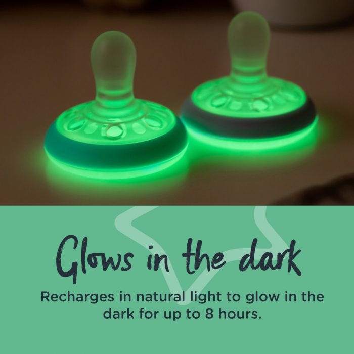 Two breast-like night soothers glowing in the dark with text explaining how they glow for up to 8 hours.