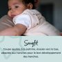parent tenant son enfant dans une pochette rose : la pochette est bien ajustée pour un bon développement des hanches