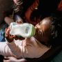 Baby feeding from a Closer to Nature glass baby bottle.
